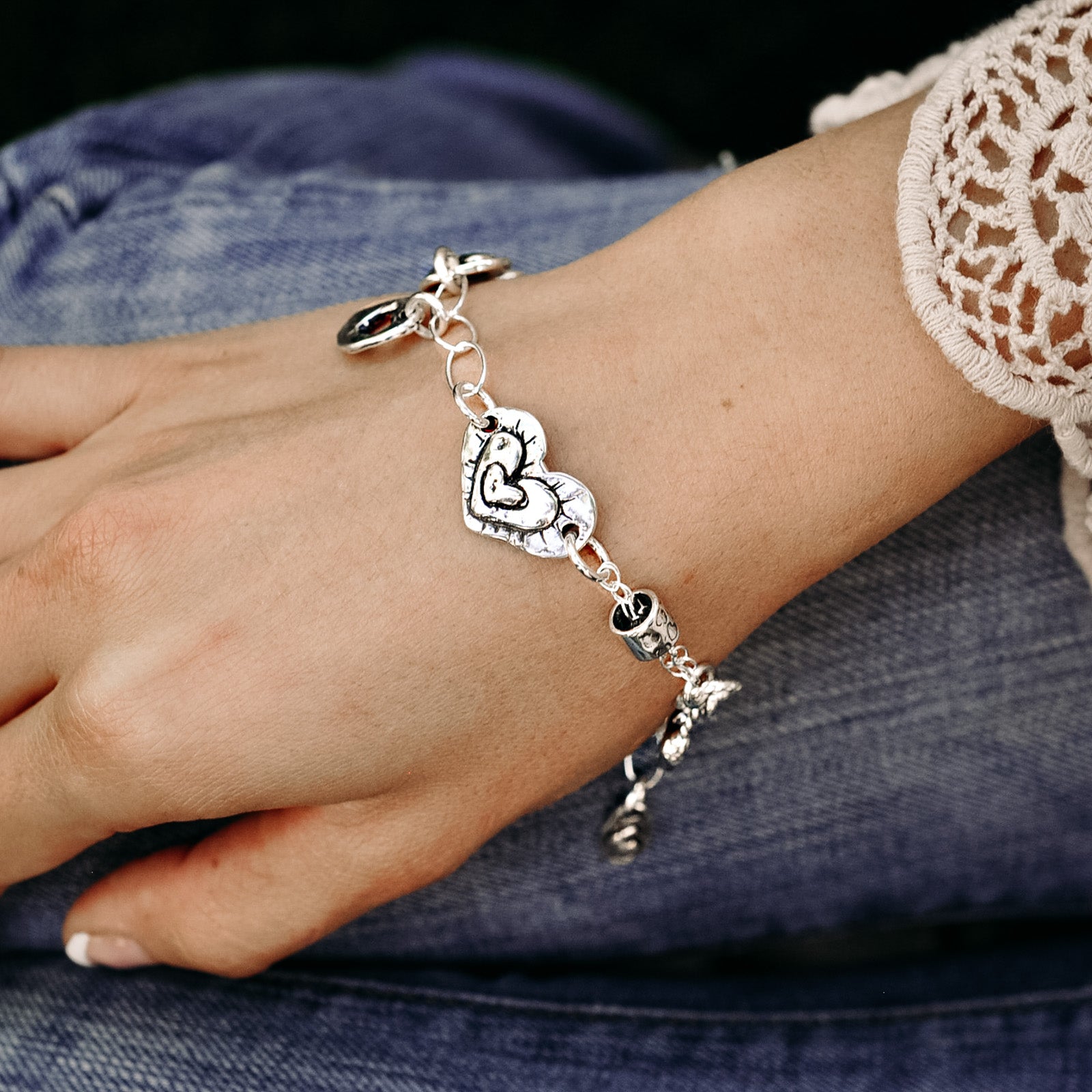 Heart love token bracelets shown next to the Omne Bonum (Latin for